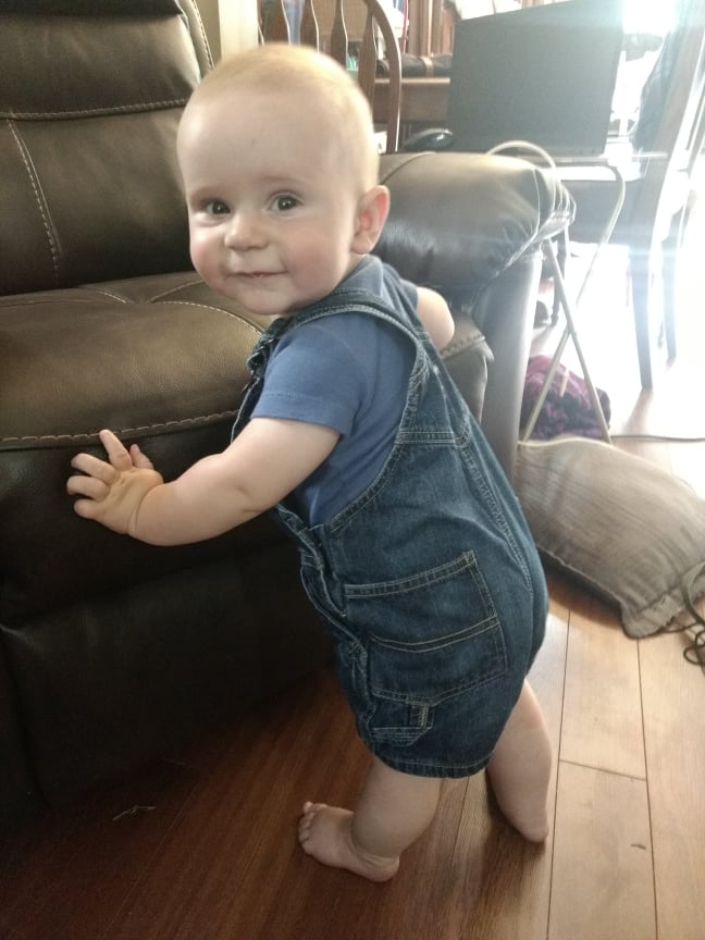 My baby at nine months, standing against a chair